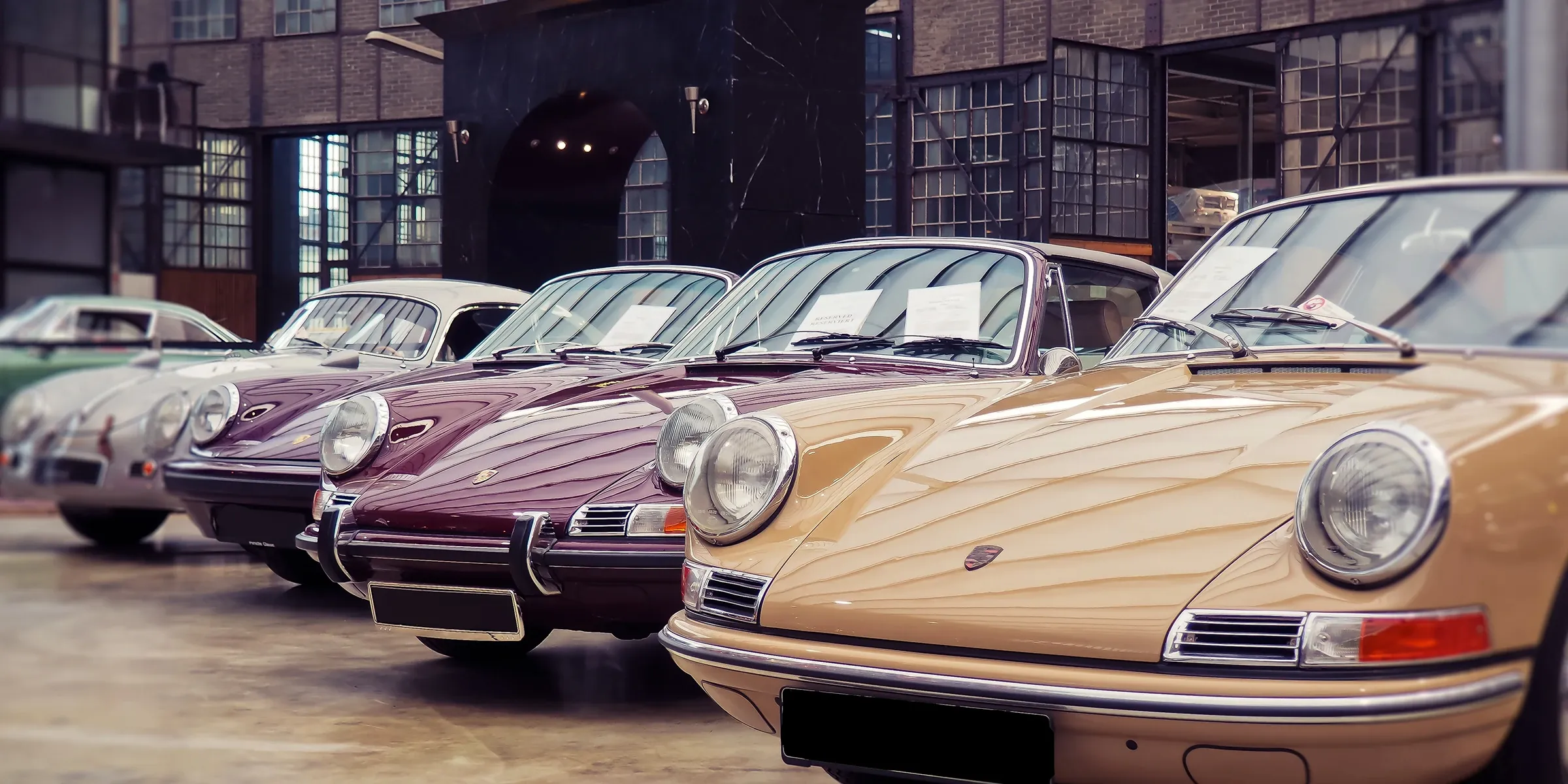 A lineup of vintage Porsche 911s in a workshop — the heritage we work on